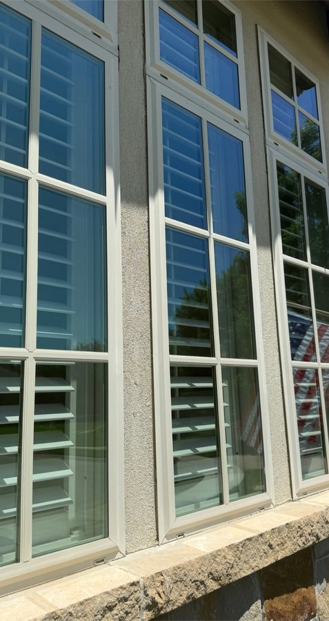 Crisp grid windows on stucco with an American flag reflection