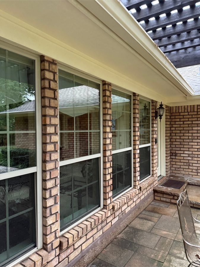Four streak-free windows on a brick home after a wash