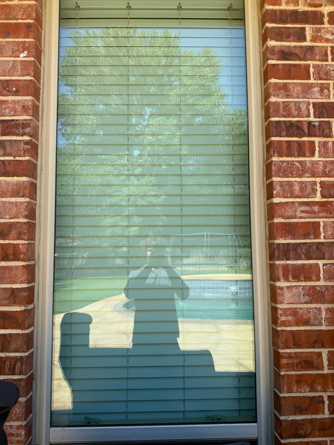 Clean window on red brick with the pool reflected in the glass
